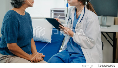 Caucasian doctor smiling take care of a young patient in hospital. Friendly nurse or therapeutic treat client Professional Caucasian doctor smiling take care of a young patient in hospital. Friendly nurse or therapeutic treat client Professional 134889853