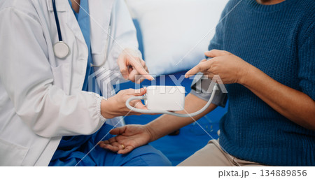 Caucasian doctor smiling take care of a young patient in hospital. Friendly nurse or therapeutic treat client Professional 134889856