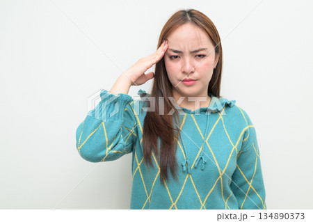 Portrait of a young Asian woman against white background stressed with headache 134890373