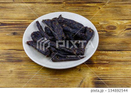 Slices of biltong (South African dried meat) on wooden table Slices of biltong (South African dried meat) on wooden table 134892544