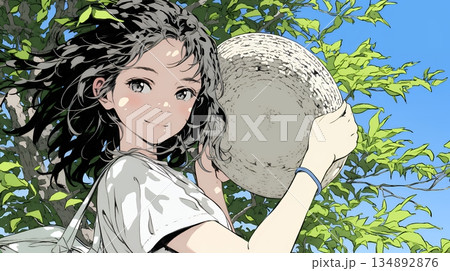 春風に飛ばされそうな帽子を、手で押さえる若い女性