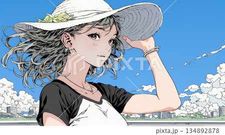 春風に飛ばされそうな帽子を、手で押さえる若い女性