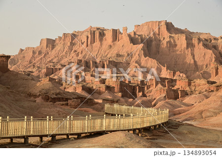 Footpath bridge at Kizil Red Stone Forest Scenic Area in Xinjiang , China is the strangely shaped red rock forests were carved by wind and sand over millions of years. Footpath bridge at Kizil Red Stone Forest Scenic Area in Xinjiang , China is the strangely shaped red rock forests were carved by wind and sand over millions of years. 134893054