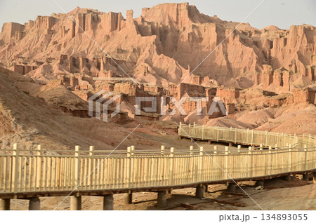 Footpath bridge at Kizil Red Stone Forest Scenic Area in Xinjiang , China is the strangely shaped red rock forests were carved by wind and sand over millions of years. Footpath bridge at Kizil Red Stone Forest Scenic Area in Xinjiang , China is the strangely shaped red rock forests were carved by wind and sand over millions of years. 134893055