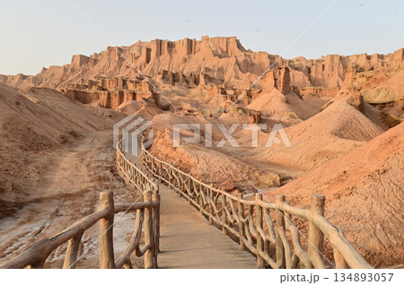 Footpath bridge at Kizil Red Stone Forest Scenic Area in Xinjiang , China is the strangely shaped red rock forests were carved by wind and sand over millions of years. Footpath bridge at Kizil Red Stone Forest Scenic Area in Xinjiang , China is the strangely shaped red rock forests were carved by wind and sand over millions of years. 134893057