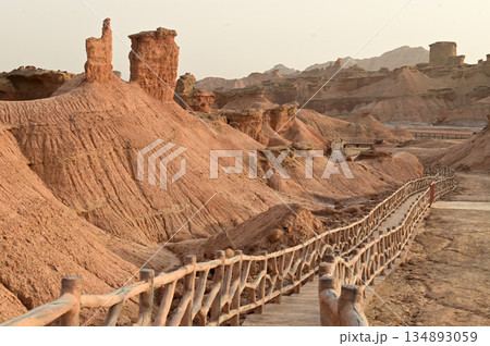 Footpath bridge at Kizil Red Stone Forest Scenic Area in Xinjiang , China is the strangely shaped red rock forests were carved by wind and sand over millions of years. Footpath bridge at Kizil Red Stone Forest Scenic Area in Xinjiang , China is the strangely shaped red rock forests were carved by wind and sand over millions of years. 134893059