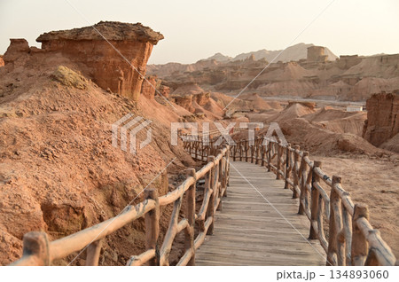 Footpath bridge at Kizil Red Stone Forest Scenic Area in Xinjiang , China is the strangely shaped red rock forests were carved by wind and sand over millions of years. 134893060