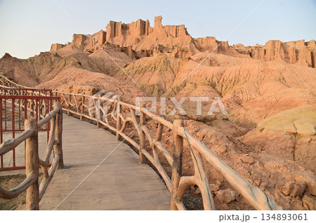 Footpath bridge at Kizil Red Stone Forest Scenic Area in Xinjiang , China is the strangely shaped red rock forests were carved by wind and sand over millions of years. 134893061