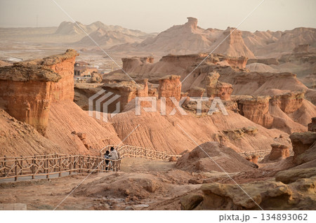 Footpath bridge at Kizil Red Stone Forest Scenic Area in Xinjiang , China is the strangely shaped red rock forests were carved by wind and sand over millions of years. Footpath bridge at Kizil Red Stone Forest Scenic Area in Xinjiang , China is the strangely shaped red rock forests were carved by wind and sand over millions of years. 134893062