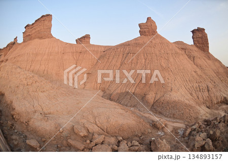 Kizil Red Stone Forest Scenic Area in Xinjiang , China is the strangely shaped red rock forests were carved by wind and sand over millions of years, giving them the appearance of abandoned cities. 134893157