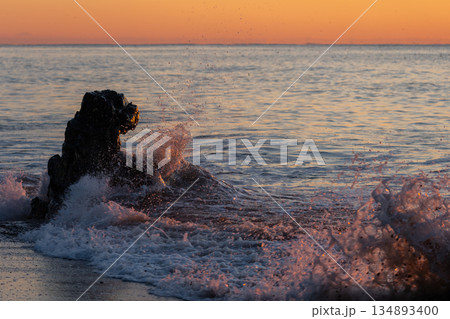 岩に打ち寄せる波 134893400