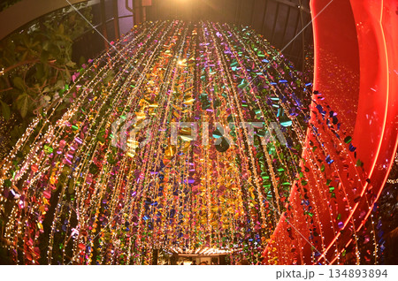 Texture and background of Plastic hanging with strings, illuminated with colored lights, sparkling and beautiful for Christmas day decorations. 134893894