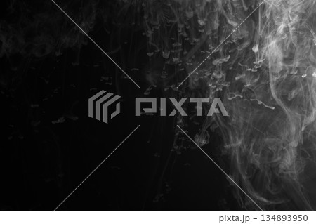 Abstract white smoke and fog drifting on dark black background with ample copy space, atmospheric texture for overlays and design 134893950