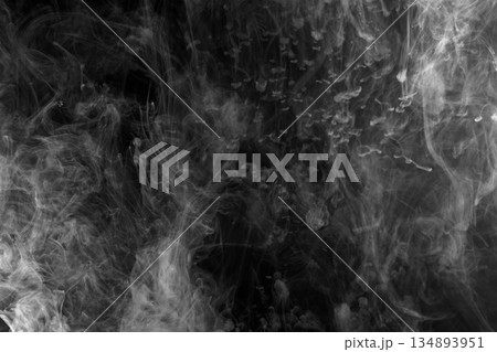 Abstract white smoke and fog drifting on dark black background with ample copy space, atmospheric texture for overlays and design 134893951