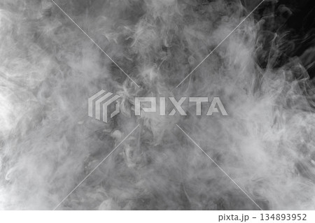Abstract white smoke and fog drifting on dark black background with ample copy space, atmospheric texture for overlays and design Abstract white smoke and fog drifting on dark black background with ample copy space, atmospheric texture for overlays and design 134893952