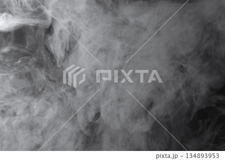 Abstract white smoke and fog drifting on dark black background with ample copy space, atmospheric texture for overlays and design Abstract white smoke and fog drifting on dark black background with ample copy space, atmospheric texture for overlays and design 134893953