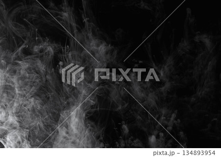 Abstract white smoke and fog drifting on dark black background with ample copy space, atmospheric texture for overlays and design Abstract white smoke and fog drifting on dark black background with ample copy space, atmospheric texture for overlays and design 134893954