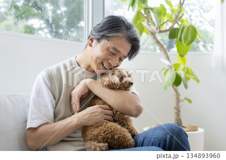 愛犬を抱く中高年男性　犬との暮らしイメージ 134893960