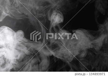 Abstract white smoke and fog drifting on dark black background with ample copy space, atmospheric texture for overlays and design 134893971
