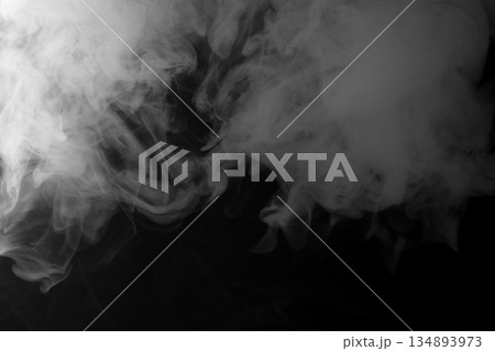 Abstract white smoke and fog drifting on dark black background with ample copy space, atmospheric texture for overlays and design Abstract white smoke and fog drifting on dark black background with ample copy space, atmospheric texture for overlays and design 134893973