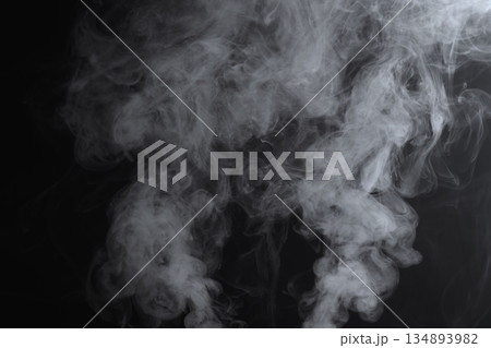 Abstract white smoke and fog drifting on dark black background with ample copy space, atmospheric texture for overlays and design Abstract white smoke and fog drifting on dark black background with ample copy space, atmospheric texture for overlays and design 134893982