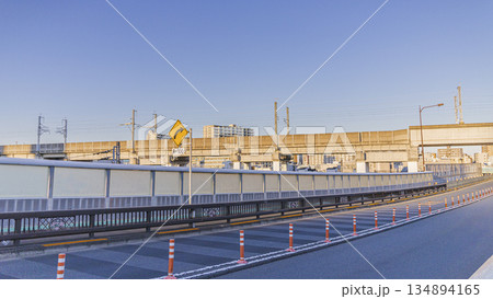 高架線路沿いの都市道路とカーブ標識 夕方の街並み 高架線路沿いの都市道路とカーブ標識 夕方の街並み 134894165