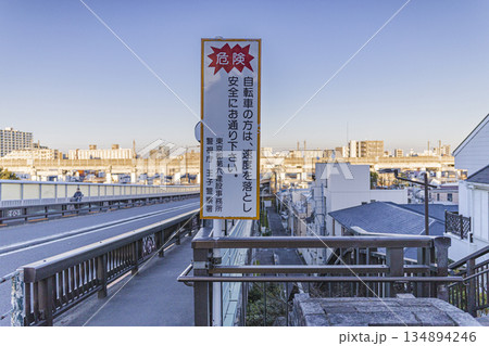 自転車減速を促す注意標識のある歩道橋 住宅街と高架道路の風景 自転車減速を促す注意標識のある歩道橋 住宅街と高架道路の風景 134894246