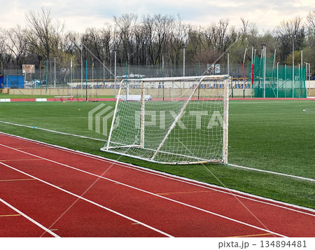 An empty soccer field with goalpost and running track. An empty soccer field with goalpost and running track. 134894481