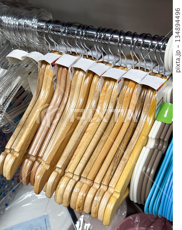 Wooden hangers on a rack for clothing organization. 134894496
