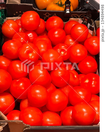 A crate filled with fresh, ripe tomatoes at a market. 134894498