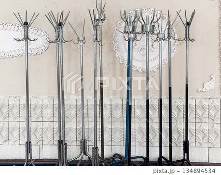 Metal coat racks standing against a decorative wall. 134894534