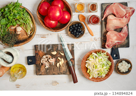 Preparing fresh ingredients for cooking in a kitchen setting with various foods and tools 134894824