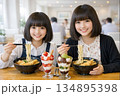 レストランで天ぷらうどんを食べる姉妹 134895398