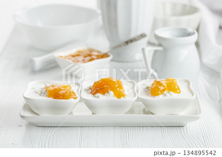 Cottage cheese with cream and mango jam on a white table. 134895542