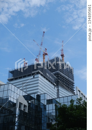 Modern Skyscraper Construction Rising Towards Blue Sky Modern Skyscraper Construction Rising Towards Blue Sky 134895661