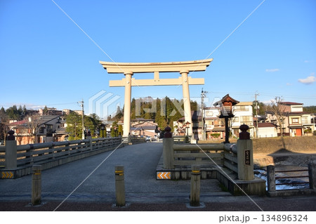 岐阜県の高山市　春の高山祭期間中　櫻山八幡宮の大鳥居と宮前橋　市街地を流れる宮川と周辺の街並み 134896324