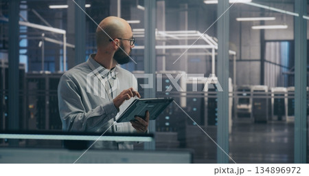 On Site Coordination, IT Specialist Using Tablet to Diagnose Rack Status 134896972