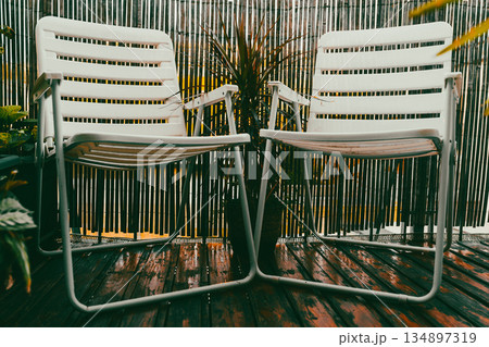 Garden white plastic chairs on terrace with mini balcony garden 134897319