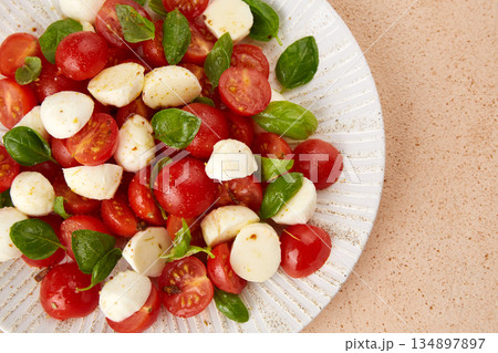 Italian caprese salad with sliced tomatoes, mozzarella, basil and olive oil 134897897
