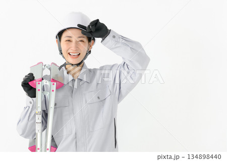 作業服姿で脚立を持つ女性 134898440