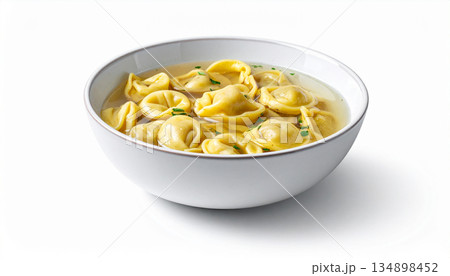 A shallow bowl of clear broth contains several small, handmade tortellini pasta filled with meat. A shallow bowl of clear broth contains several small, handmade tortellini pasta filled with meat. 134898452