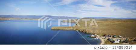 Lake Baikal on a sunny summer day. Panorama of the Olkhon Gate Strait. A ferry carries passengers to Olkhon Island. 134899014