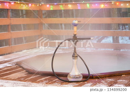 Serene setting featuring hookah and snowy winter atmosphere Serene setting featuring hookah and snowy winter atmosphere 134899200