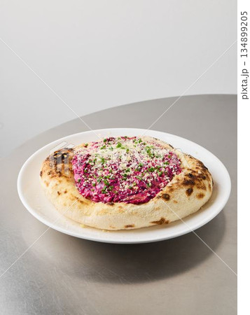 Radiant beet dish served alongside aromatic herbal cheese spread 134899205