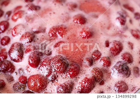 Red berries bubbling in a pot during the simmering process for a fresh homemade jam Red berries bubbling in a pot during the simmering process for a fresh homemade jam 134899298