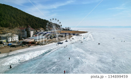 Lake Baikal in early spring. Listvyanka village, a popular place for traveling. Lake Baikal in early spring. Listvyanka village, a popular place for traveling. 134899459