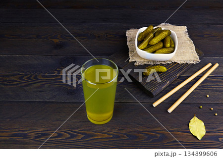 Cucumber pickle or pickle juice in glass, a bowl with pickled gherkins 134899606