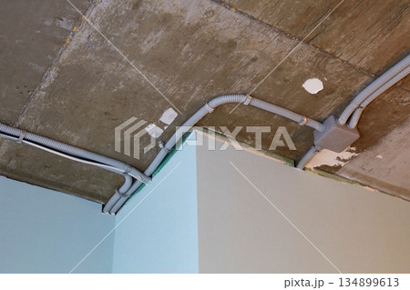 The electrical wires in the protective corrugated cable tube and the junction box are neatly laid on the ceiling The electrical wires in the protective corrugated cable tube and the junction box are neatly laid on the ceiling 134899613