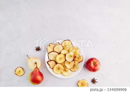Apple and pear chips on a plate. Homemade fruit dried sliced. 134899906