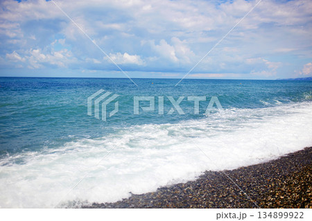 Sea summer landscape. The turquoise color of the water, the sea is stormy, the pebble beach. 134899922